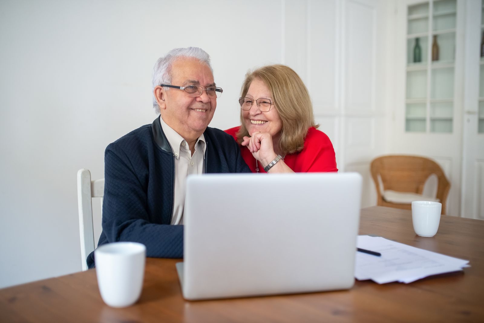 Couple souriant devant un ordinateur portable